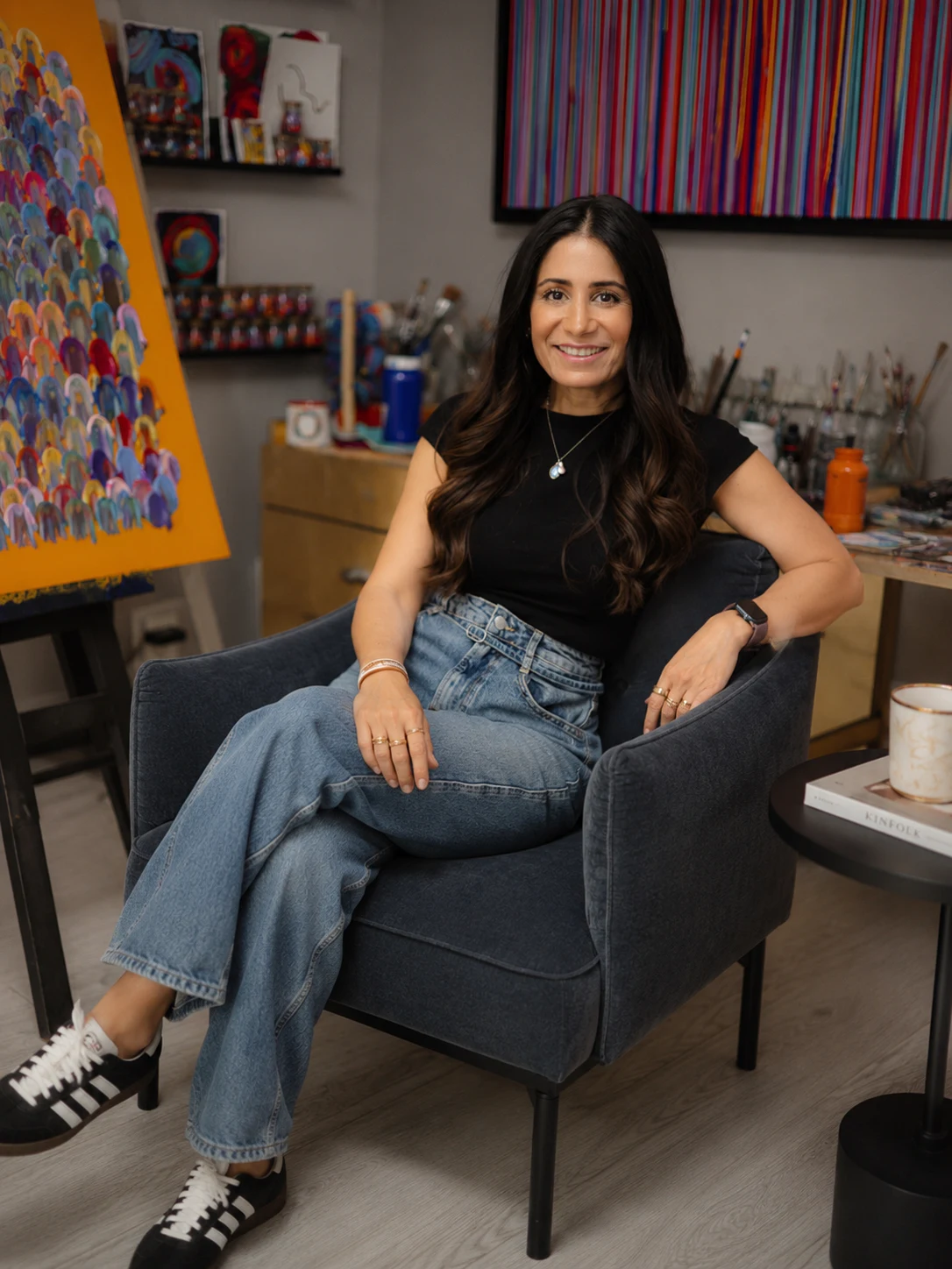 Olinka en su estudio rodeada de sus pinturas